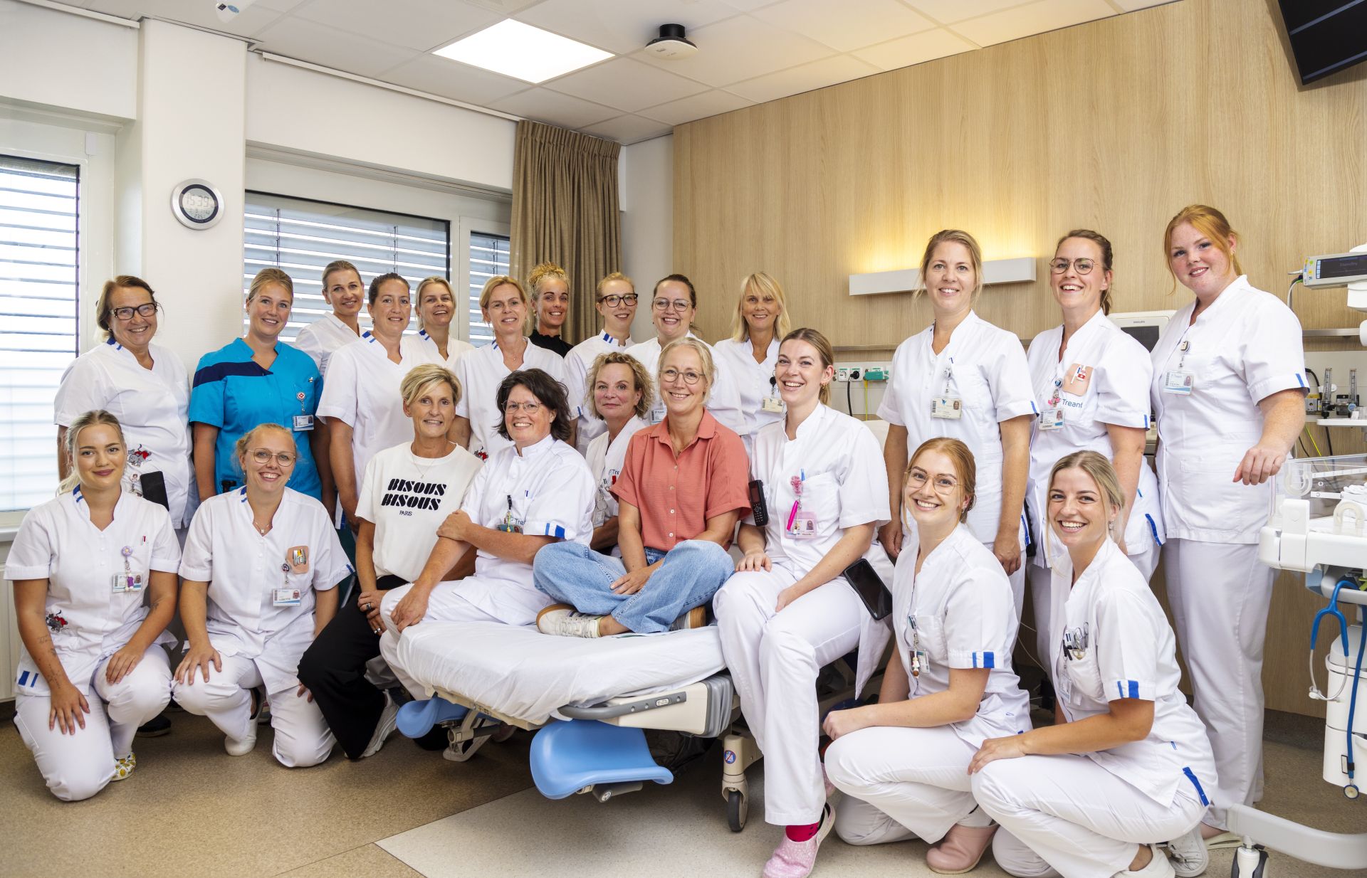 Een groep professionals in uniform poseren samen in een medische omgeving.