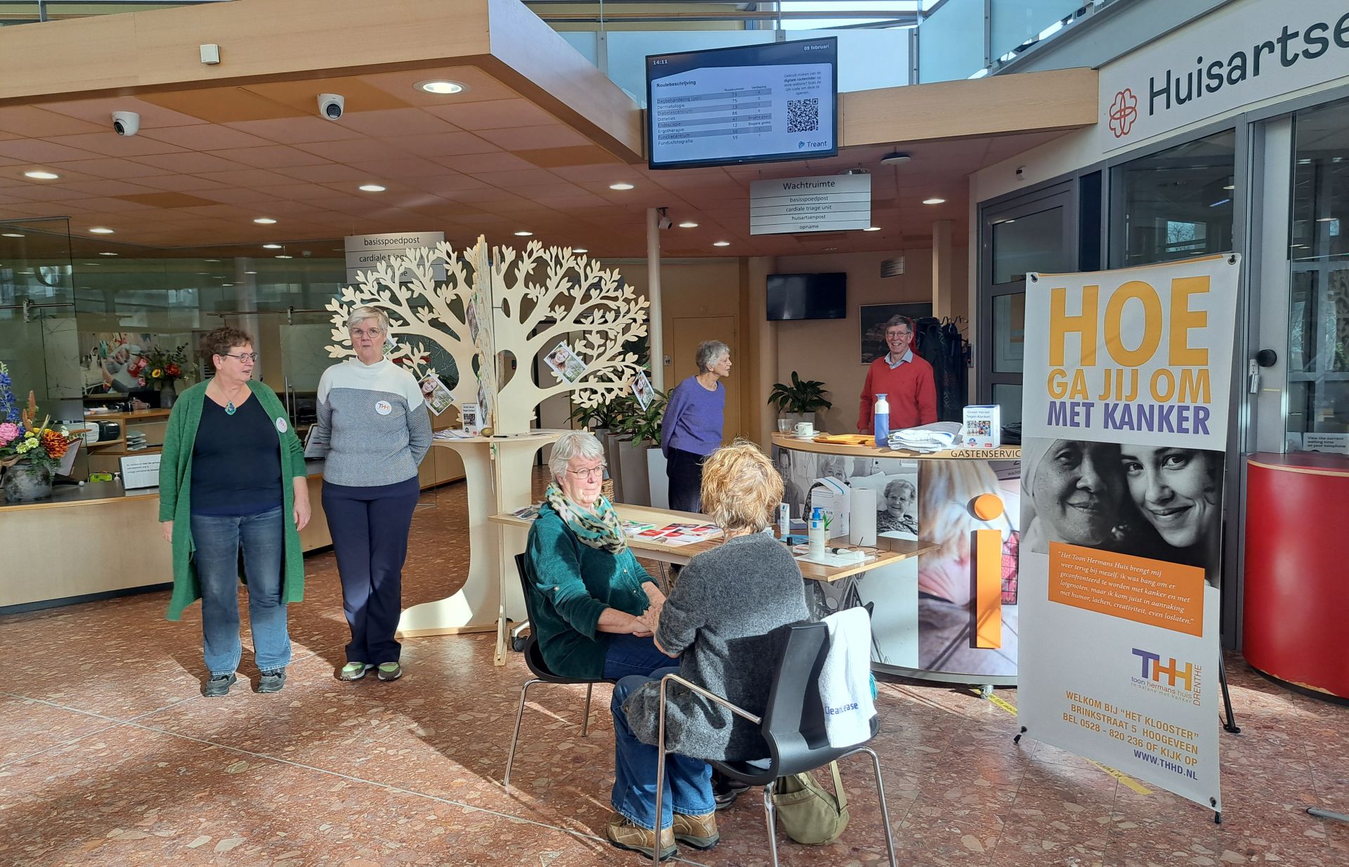 Toon Hermans Huis biedt extra ondersteuning bij kanker. je ziet collega's bij de stand staan en zitten