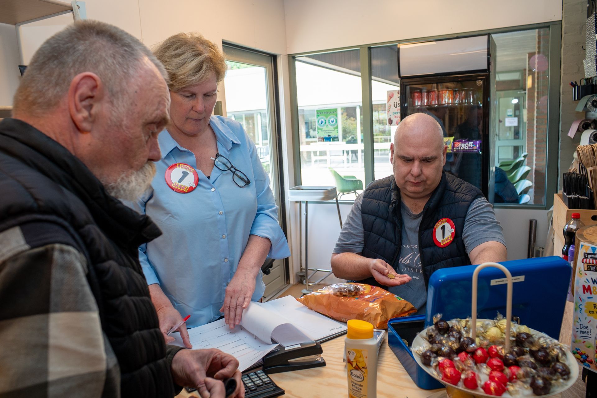 Mensen aan het werk aan een tafel met documenten en een schaal met druiven.