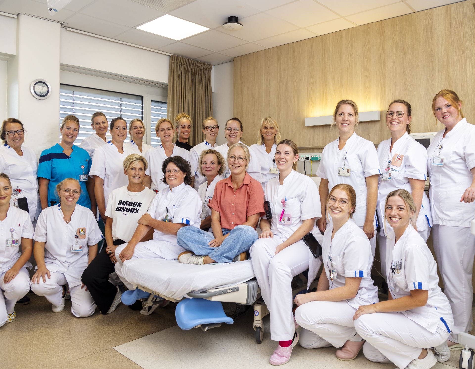 Een groep professionals in uniform poseren samen in een medische omgeving.